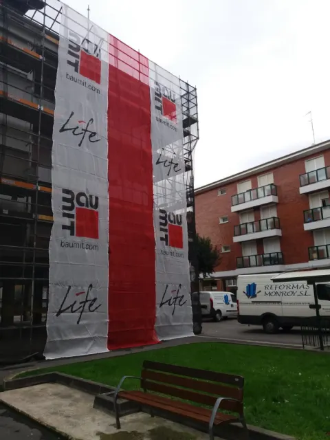 Obra de Reformas Monroy con andamio y lona de la empresa en una fachada